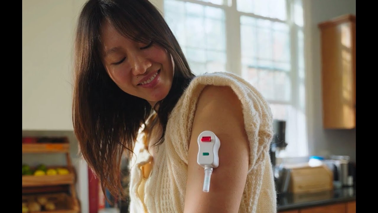 Woman using an EasyDraw blood collector on her upper arm at home